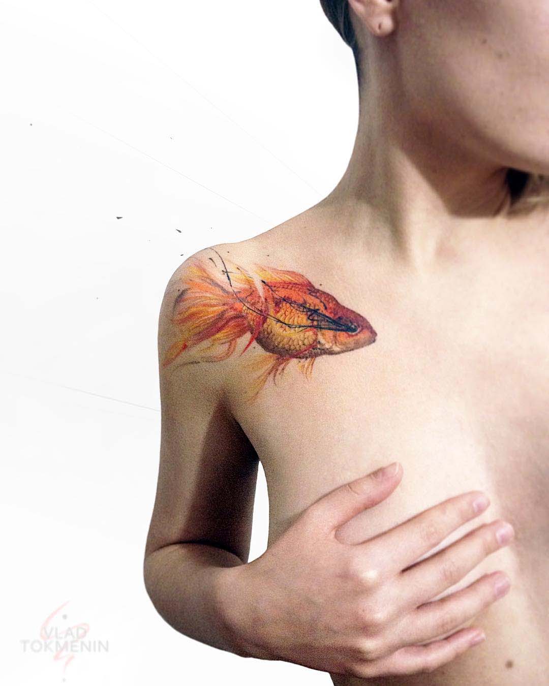 gold fish tattoo on collar bone